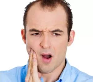 Man touching jaw in discomfort, seeking relief from Emergency Dentist Paddington for dental pain